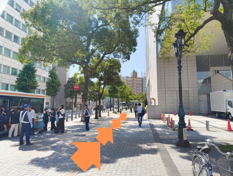 名古屋金山駅前の広々とした歩道と木々。ただたんパーソナルジム金山への案内矢印。