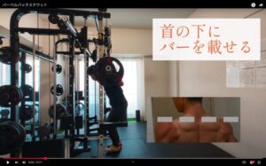 ただたんパーソナルジム金山で、トレーナーがバーベルバックスクワットの正しいフォームを指導している様子。