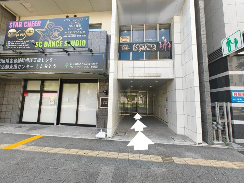 1階に地域活動支援センターがある金山伏見通ビルの入り口。奥へ進む白い矢印。