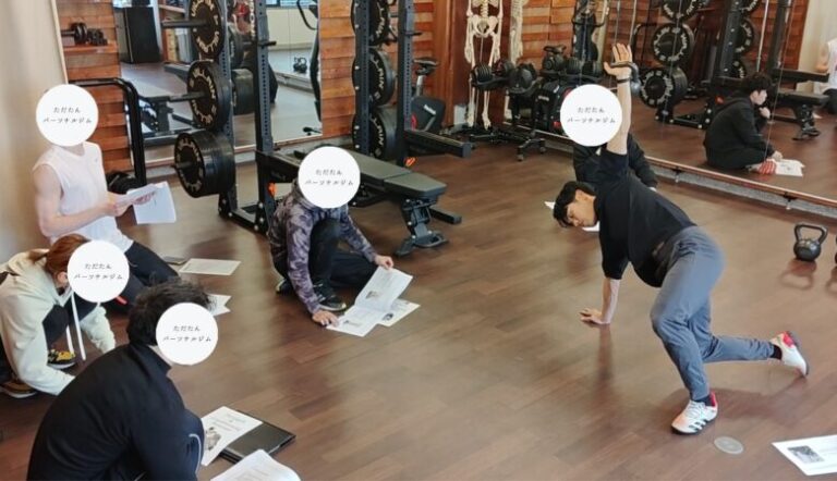 金山のパーソナルジム「ただたん」代表が、セミナー会場にてケトルベルを頭上に掲げ、ターキッシュゲットアップの動作を正確なフォームで実演している様子。